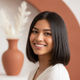 Portrait of a smiling young woman with straight hair, looking confidently at the camera.